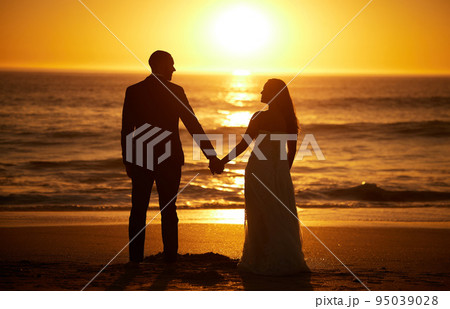 Love, summer and couple at a beach at sunset, silhouette holding hands and bonding with ocean views in nature. Romance, travel and nature with man and woman enjoying sea honeymoon and romantic trip Love, summer and couple at a beach at sunset, silhouette holding hands and bonding with ocean views in nature. Romance, travel and nature with man and woman enjoying sea honeymoon and romantic trip 95039028