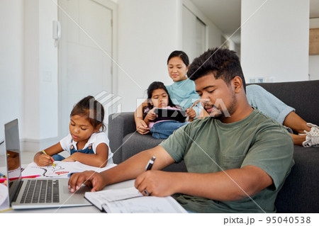 Family, children and education with a father working from home and his daughter doing homework for school. Learning, remote work and studying with a young girl and her dad busy in the living room 95040538