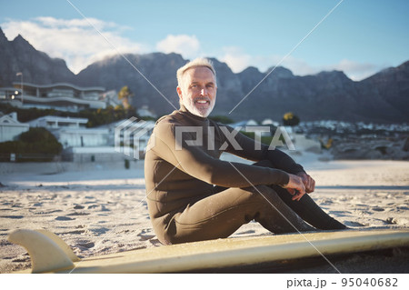 Surf, sports and sand with a mature man on the beach for surfing, fitness and exercise while on summer holiday. Workout, training and health with a surfer and his surfboard enjoying retirement travel 95040682