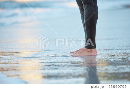 Surf, water and legs of man on the beach for fun adventure, fitness and exercise workout in Rio de Janeiro Brazil. Sand, wellness peace and feet of surfer with wetsuit for sports surfing in ocean sea 95040795