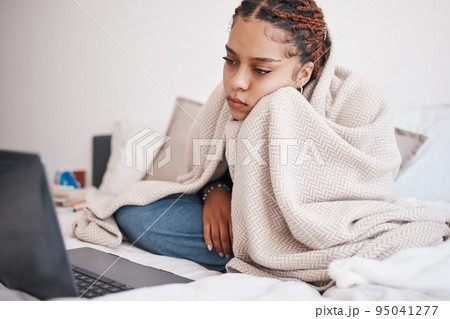 Depression, bed and woman streaming on a laptop, looking sad and lonely while searching for online comfort in bedroom. Mental health, anxiety and insomnia by bored black girl watching movie in home 95041277