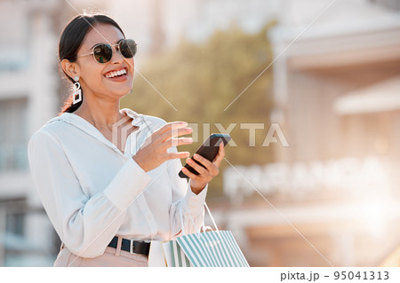 Fashion, shopping and bag with woman and phone for social media, sale and retail in New york city street. Luxury, customer and gift with girl and 5g for internet, communication or contact with mobile 95041313