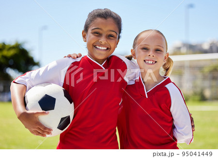 Portrait of girls on field, sports and soccer player, smiling with teammate. Soccer ball, football and young kids having fun on summer day before match or game. Team, friends and teamwork in sport Portrait of girls on field, sports and soccer player, smiling with teammate. Soccer ball, football and young kids having fun on summer day before match or game. Team, friends and teamwork in sport 95041449