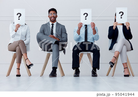 Man at in line at hiring company smile for interview, in waiting room to see manager or boss. Professional male in group of people with question mark paper or posters over face for job recruitment 95041944