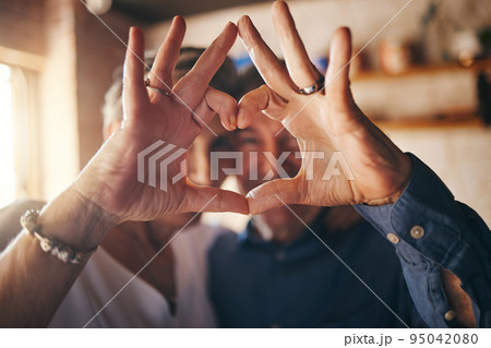 Love, hands and heart sign with senior couple relax and bonding in their home together, cheerful and in love. Support, soulmate and loving man and woman sharing romantic moment and enjoy relationship Love, hands and heart sign with senior couple relax and bonding in their home together, cheerful and in love. Support, soulmate and loving man and woman sharing romantic moment and enjoy relationship 95042080