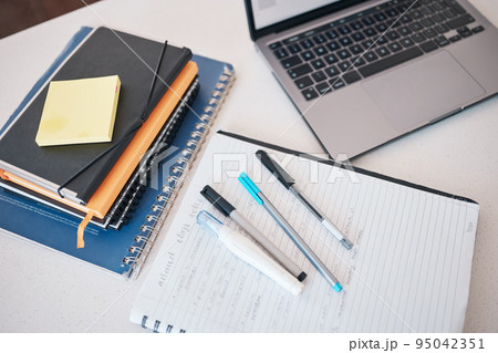 Paper, writing and idea with a notebook, laptop and books on a desk in an empty office for planning at work. Computer, email and strategy with still life objects on a table for business or creativity 95042351