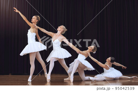 Ballet, dancing and group stage performance at an art theatre with creative movement. Dancers, flexible and young women ballerinas dance elegantly together performing swan lake play in costumes Ballet, dancing and group stage performance at an art theatre with creative movement. Dancers, flexible and young women ballerinas dance elegantly together performing swan lake play in costumes 95042539