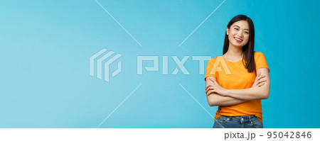 Cheerful friendly asian woman with dark short haircut smiling broadly enthusiastic conversation, talking you casually, cross arms chest confident pose, laughing carefree, stand blue background Cheerful friendly asian woman with dark short haircut smiling broadly enthusiastic conversation, talking you casually, cross arms chest confident pose, laughing carefree, stand blue background 95042846