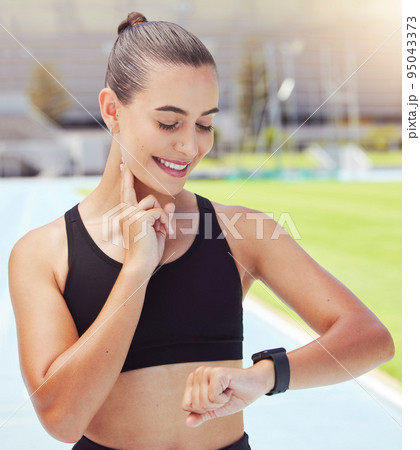 Sport, watch and time with a sports woman training during a workout and checking or tracking her progress. Health, fitness and wellness with a young female athlete timing her performance on a run 95043373