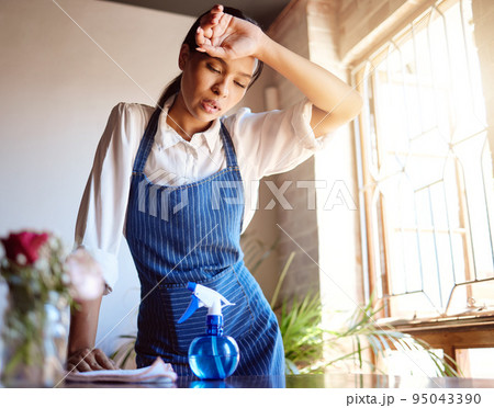 Cleaning house, burnout and tired cleaner working hard on dirty table and furniture feeling exhausted. Unhappy, frustrated and sweaty woman overworked in a difficult stressful job with daily pressure 95043390