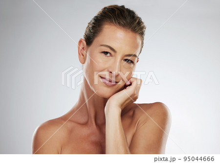 Mature woman, face and skincare routine for healthy glow on grey studio background with mockup space, healthcare wellness or collagen dermatology. Portrait, beauty model and hand on cheek with makeup 95044666