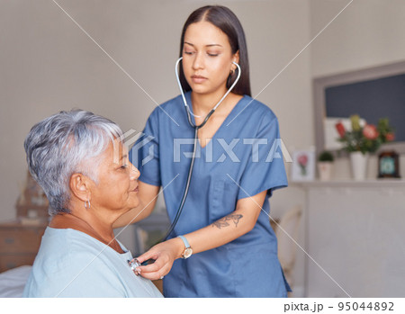Elderly patient, nursing and nurse with a stethoscope listening to heartbeat during a health consultation. Healthcare professional, senior woman and medical checkup in her room at the retirement home Elderly patient, nursing and nurse with a stethoscope listening to heartbeat during a health consultation. Healthcare professional, senior woman and medical checkup in her room at the retirement home 95044892