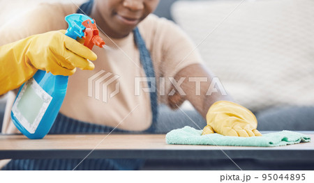 Woman with detergent to clean, spray and wipe table, in office or living room in home. Black woman in domestic work, use cloth and liquid cleaner, on desk for hygiene in lounge of business or house Woman with detergent to clean, spray and wipe table, in office or living room in home. Black woman in domestic work, use cloth and liquid cleaner, on desk for hygiene in lounge of business or house 95044895