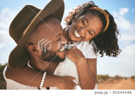 Happy, love and summer hug of a couple together with quality time in nature. Black people with happiness and a smile embracing travel, summer and the blue sky feeling relationship gratitude outdoor 95045446