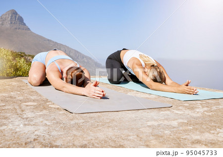 Women, yoga or zen workout on mountains in child pose for mental health, chakra energy or mind peace. Friends, people or relax fitness yogi stretching in body exercise, training or pilates meditation 95045733