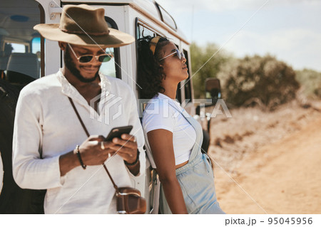 Safari travel, fashion and african couple with car and smartphone for social media update, location check and countryside lifestyle. Influencer black people or youth with summer clothes and transport 95045956