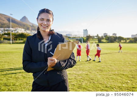Football coach, junior sports and woman with clipboard coaching children on a soccer field or pitch outside on a sunny day. Happy female pe trainer outside for practice, training and exercise class 95046074