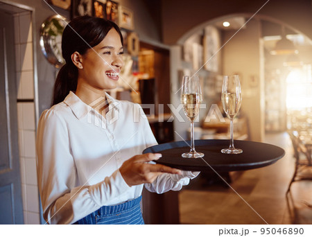 Waitress, wine glass tray and hospitality service in restaurant, cafe and fine dining winery. Happy woman, bartender and sommelier catering luxury champagne, alcohol glasses or expensive liquor drink 95046890