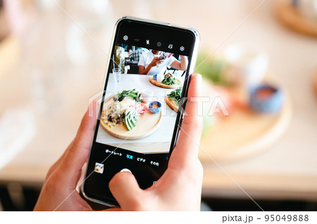 スマホで料理を撮影する手元 95049888