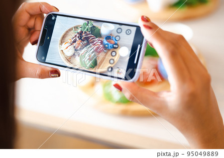 スマホで料理を撮影する手元 95049889