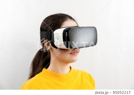 Three-quarter portrait close-up of a young woman wearing virtual reality glasses. White background. The concept of virtual reality and modern technologies 95052217