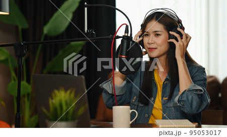 Asian woman podcasters using laptop and condenser microphone to recording podcast in home studio Asian woman podcasters using laptop and condenser microphone to recording podcast in home studio 95053017