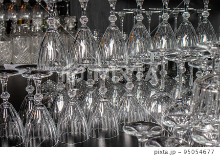 Lots of empty glass glasses for alcohol. Glass upside down. 95054677