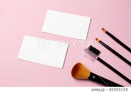 Makeup brush and white business card on pink background. A horizontal template for a makeup artist's business card or flyer design, with copy space 95055159
