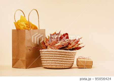 Fall Gift or Sale order and delivery concept. Shopping buff paper bag, with golden maple leaves and pumpkins. autumn mood decor warm colors. Thanksgiving. Copy space Fall Gift or Sale order and delivery concept. Shopping buff paper bag, with golden maple leaves and pumpkins. autumn mood decor warm colors. Thanksgiving. Copy space 95056424