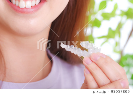 歯科用マウスピースを持つ若い女性 95057809