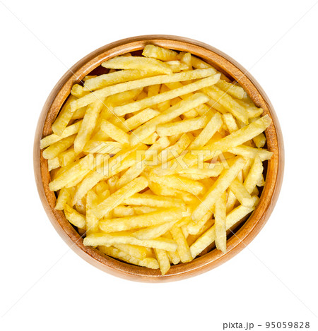 Salted potato sticks in a wooden bowl. Also called shoestring potatoes, a popular snack and variant of crispy potato chips. Extremely thin versions of French fries, deep fried in sunflower oil. 95059828