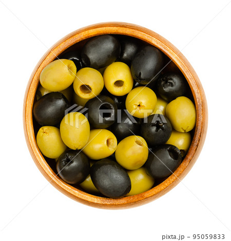 Pitted green and black olives, Hojiblanca, in a wooden bowl. European olives, Olea europaea, a cultivar from Lucena in Spain, mainly grown in Andalucia. Popular table olives with a lower oil content. 95059833