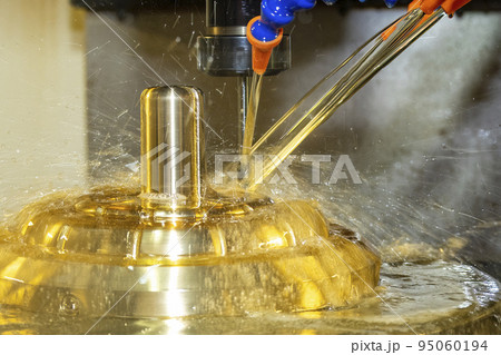 The CNC milling machine cutting the brass material part with oil coolant method. 95060194
