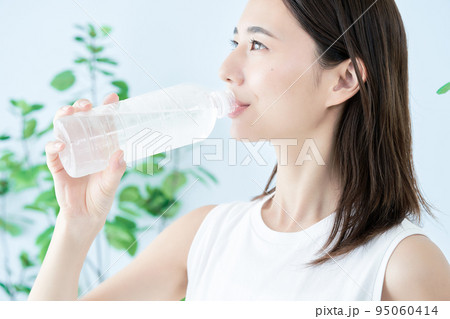 ペットボトルの水を飲む若い女性 95060414