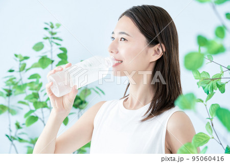 ペットボトルの水を飲む若い女性 95060416