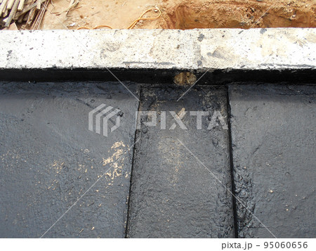 MELAKA, MALAYSIA -JULY 1, 2022: Waterproofing membrane applied by construction workers on top of the concrete slab. Waterproofing layer to prevent water from penetrating below the concrete slab. MELAKA, MALAYSIA -JULY 1, 2022: Waterproofing membrane applied by construction workers on top of the concrete slab. Waterproofing layer to prevent water from penetrating below the concrete slab. 95060656