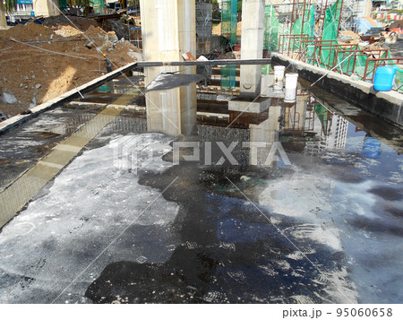 MELAKA, MALAYSIA -JULY 1, 2022: Waterproofing membrane applied by construction workers on top of the concrete slab. Waterproofing layer to prevent water from penetrating below the concrete slab. MELAKA, MALAYSIA -JULY 1, 2022: Waterproofing membrane applied by construction workers on top of the concrete slab. Waterproofing layer to prevent water from penetrating below the concrete slab. 95060658