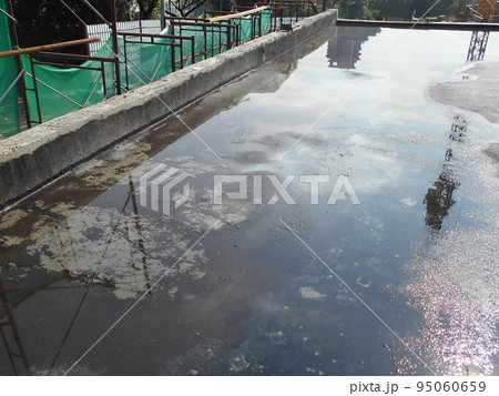 MELAKA, MALAYSIA -JULY 1, 2022: Waterproofing membrane applied by construction workers on top of the concrete slab. Waterproofing layer to prevent water from penetrating below the concrete slab. MELAKA, MALAYSIA -JULY 1, 2022: Waterproofing membrane applied by construction workers on top of the concrete slab. Waterproofing layer to prevent water from penetrating below the concrete slab. 95060659