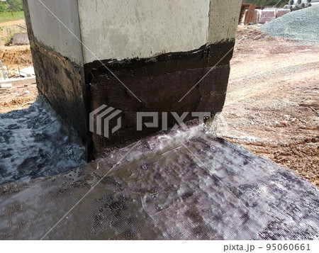 MELAKA, MALAYSIA -JULY 1, 2022: Waterproofing membrane applied by construction workers on top of the concrete slab. Waterproofing layer to prevent water from penetrating below the concrete slab. MELAKA, MALAYSIA -JULY 1, 2022: Waterproofing membrane applied by construction workers on top of the concrete slab. Waterproofing layer to prevent water from penetrating below the concrete slab. 95060661