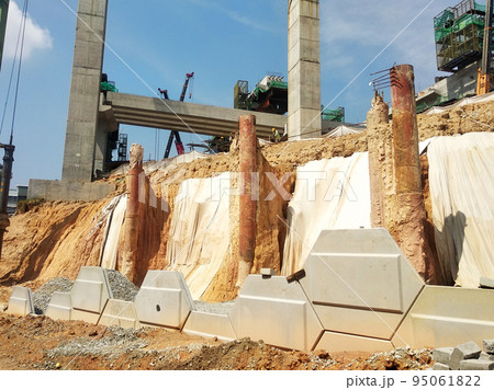 MELAKA, MALAYSIA - JULY 6, 2022: Slopes that have been cut, are temporarily covered using plastic or fabric for a while to prevent erosion caused by rainwater. This is as an immediate action. MELAKA, MALAYSIA - JULY 6, 2022: Slopes that have been cut, are temporarily covered using plastic or fabric for a while to prevent erosion caused by rainwater. This is as an immediate action. 95061822