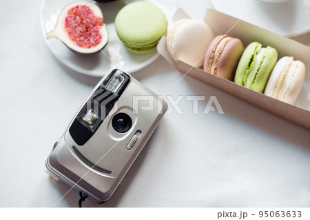 aesthetic film camera flatley, figs and macarons on white background, top view aesthetic film camera flatley, figs and macarons on white background, top view 95063633