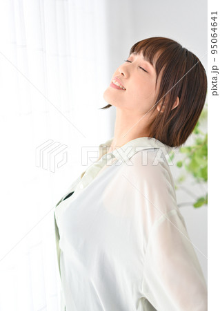 部屋でリラッスしてポーズをとる女性 95064641