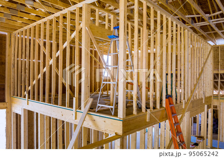 Building frame for a new residential building while it is still under construction with beams fenestrations on a construction site Building frame for a new residential building while it is still under construction with beams fenestrations on a construction site 95065242