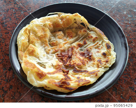 Traditional Malaysian signature flatbread food is called roti canai.  This is the type of simple pancake made from a mix of flour, egg and water. Eat with special sauce. 95065429