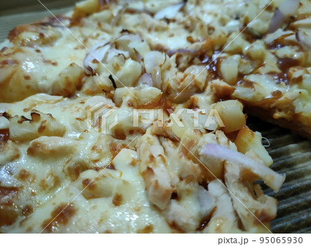 Close-up photo of the pizza slice still in the box. Pizza is made with a variety of toppings as a flavor variation with cheese as the base of the topping ingredients. 95065930