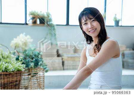 のんびりと寛ぐ若い女性 95066363