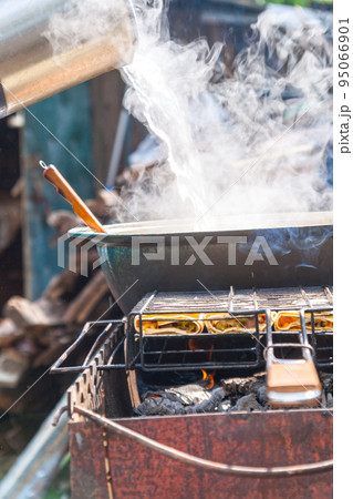 on the grill stands a cauldron in which to prepare meat and vegetables 95066901