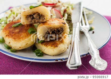 fried potato pies with mushrooms and salad on a plate fried potato pies with mushrooms and salad on a plate 95066917