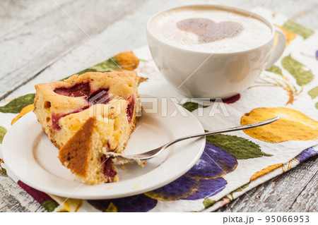 pie with plums and slice and cup with coffee pie with plums and slice and cup with coffee 95066953