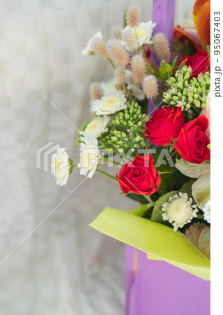 beautiful bright bouquet in a purple basket on a white background, copy space 95067403